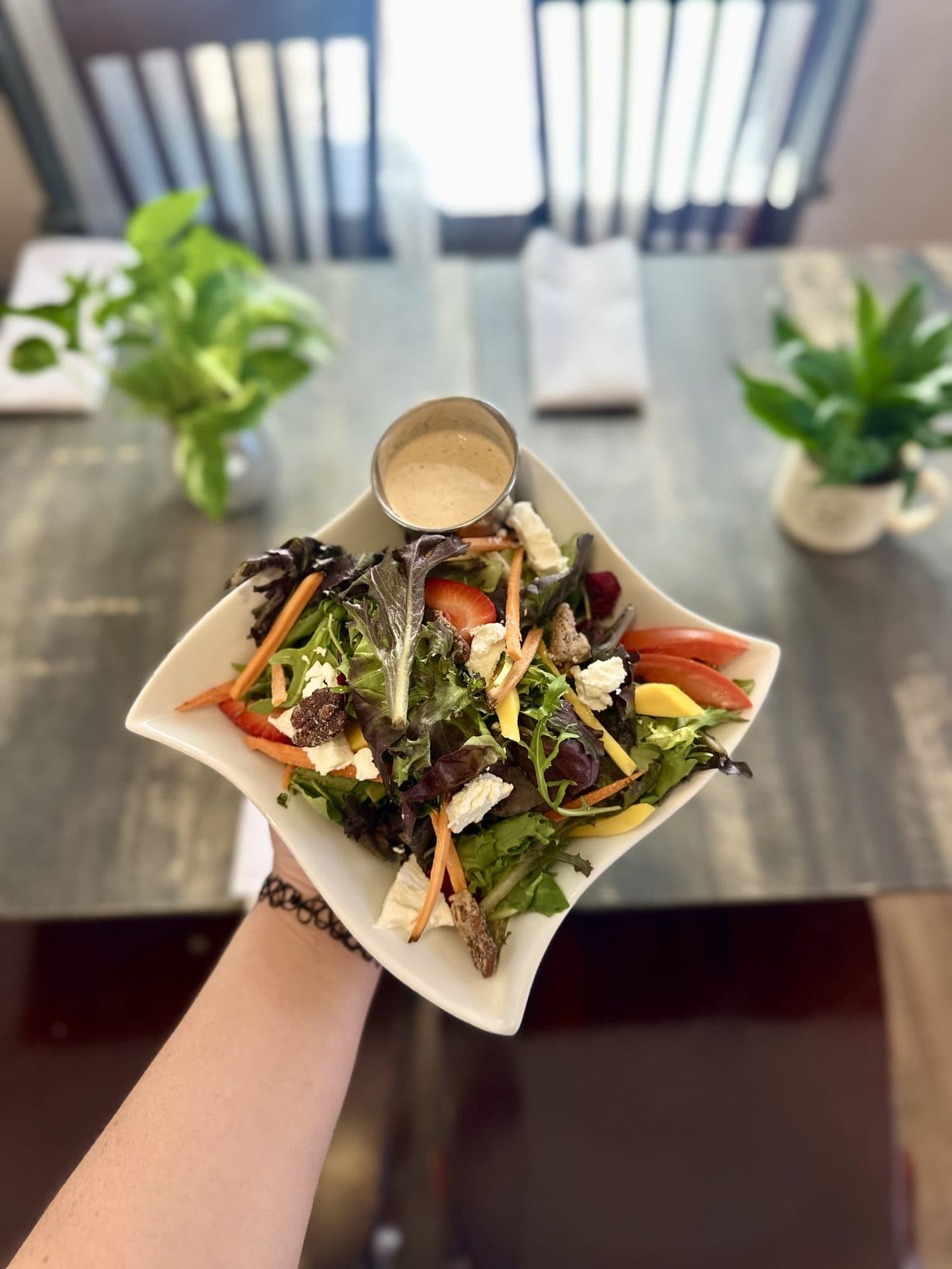 Park Greens salad held up over a table