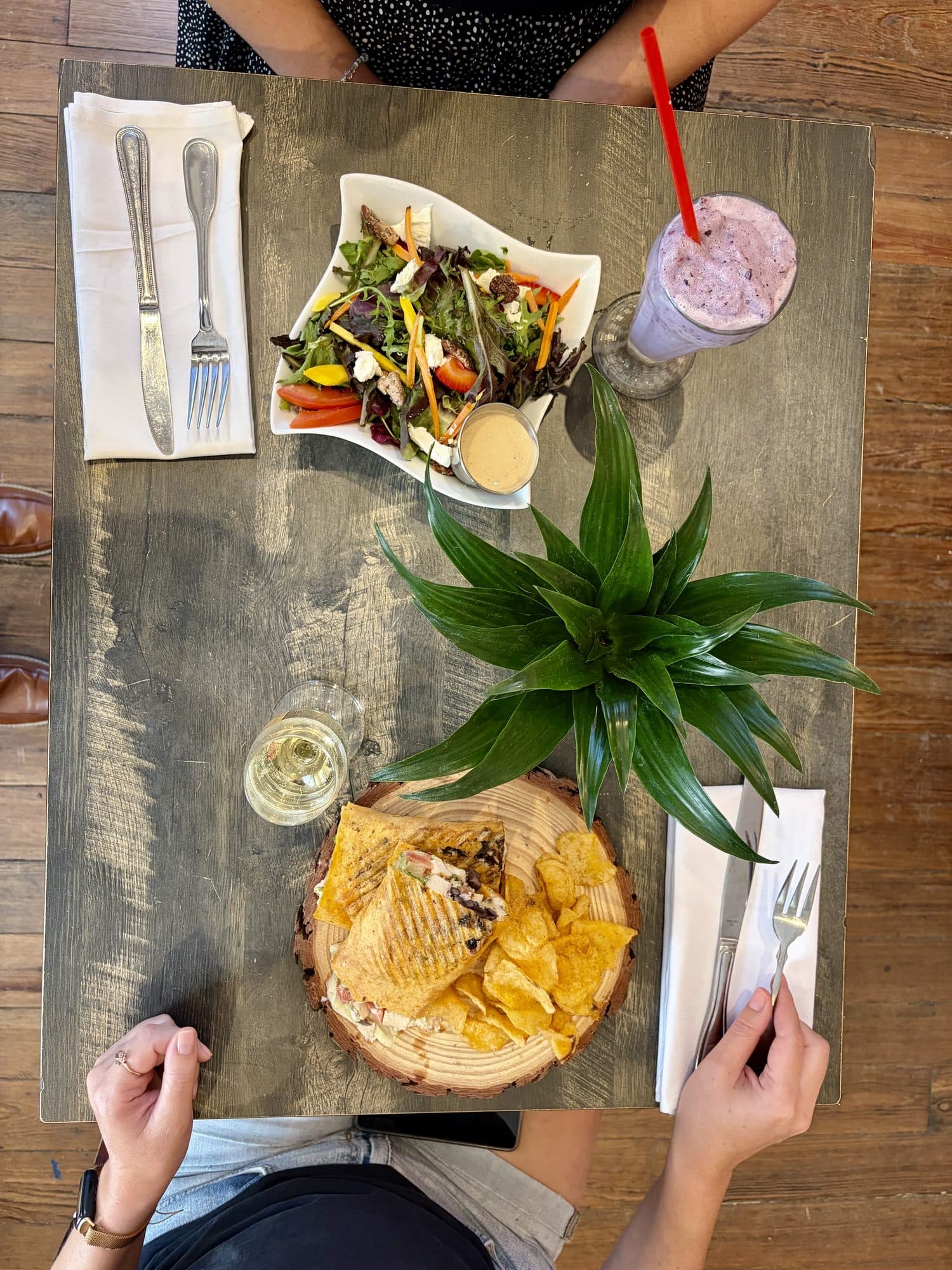 Overhead view of a table set with salad, panini and a smoothie